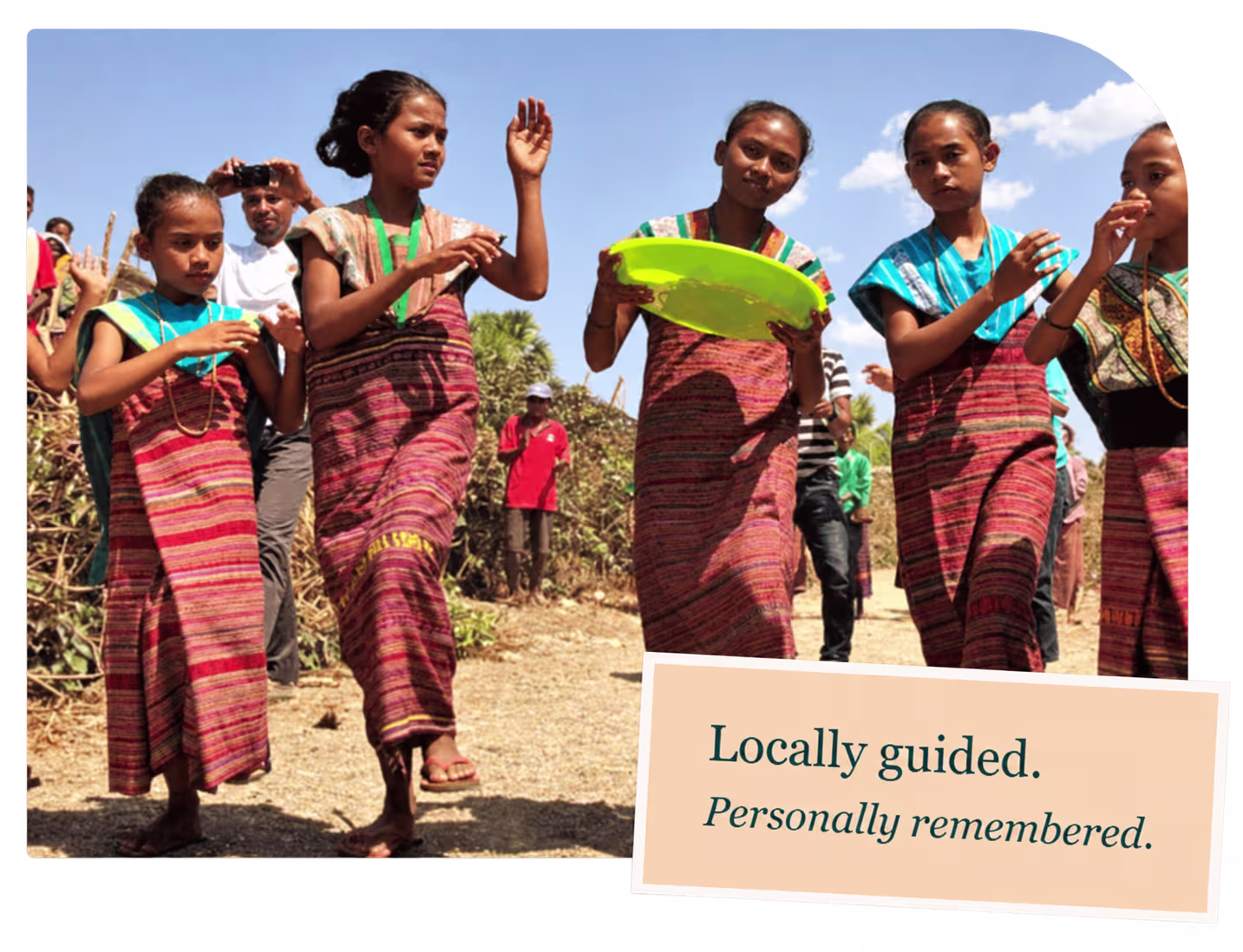 Timorese women in traditional woven tais walking together outdoors, with a caption reading Locally guided. Personally remembered.